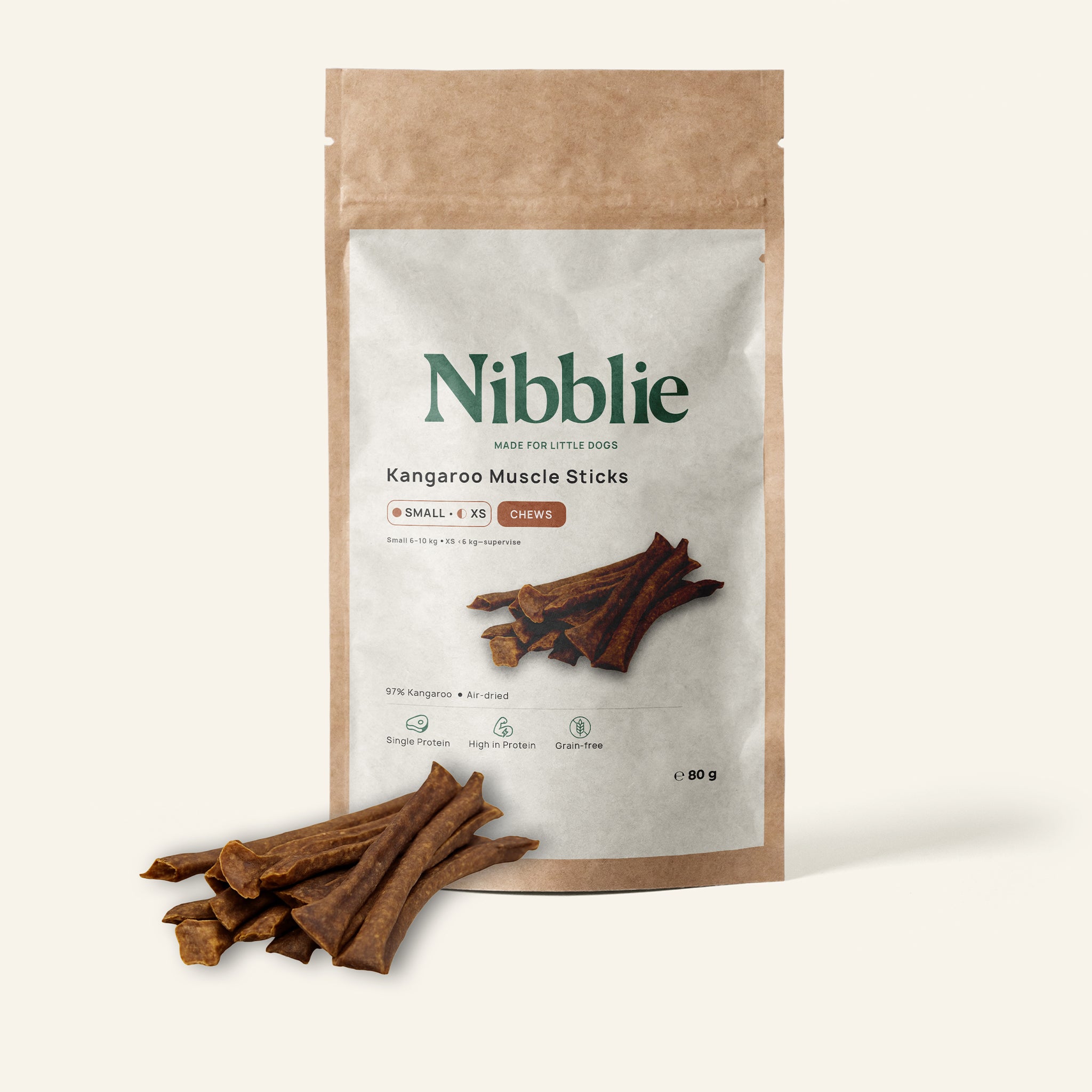 Nibblie Kangaroo Muscle Sticks 80g pack on warm linen with sticks in front; novel-protein chew for small dogs.