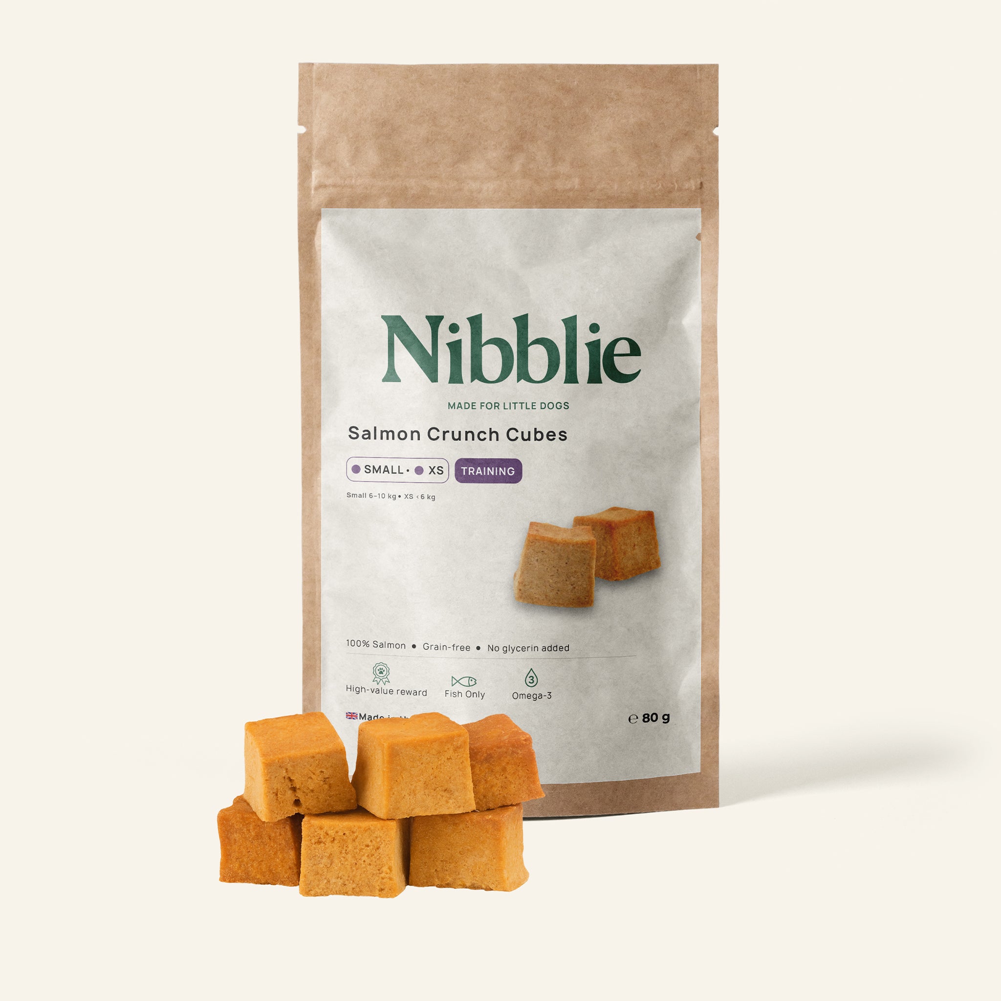 Nibblie Salmon Crunch Cubes 80g pack on warm linen with cubes in front; natural salmon treats for small dogs.