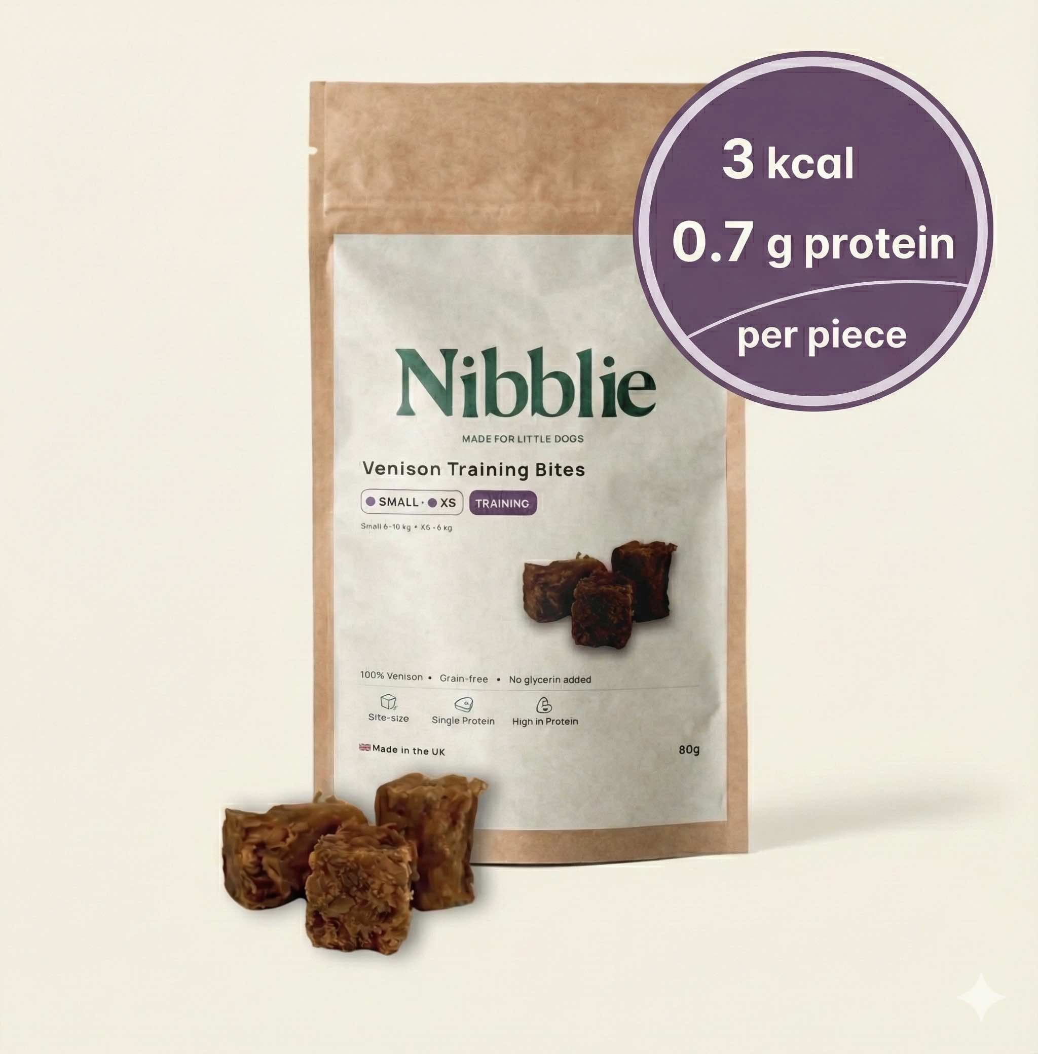Nibblie Venison Training Bites 80g pack on warm linen with bites in front; high-value, low-cal training treats for small dogs.