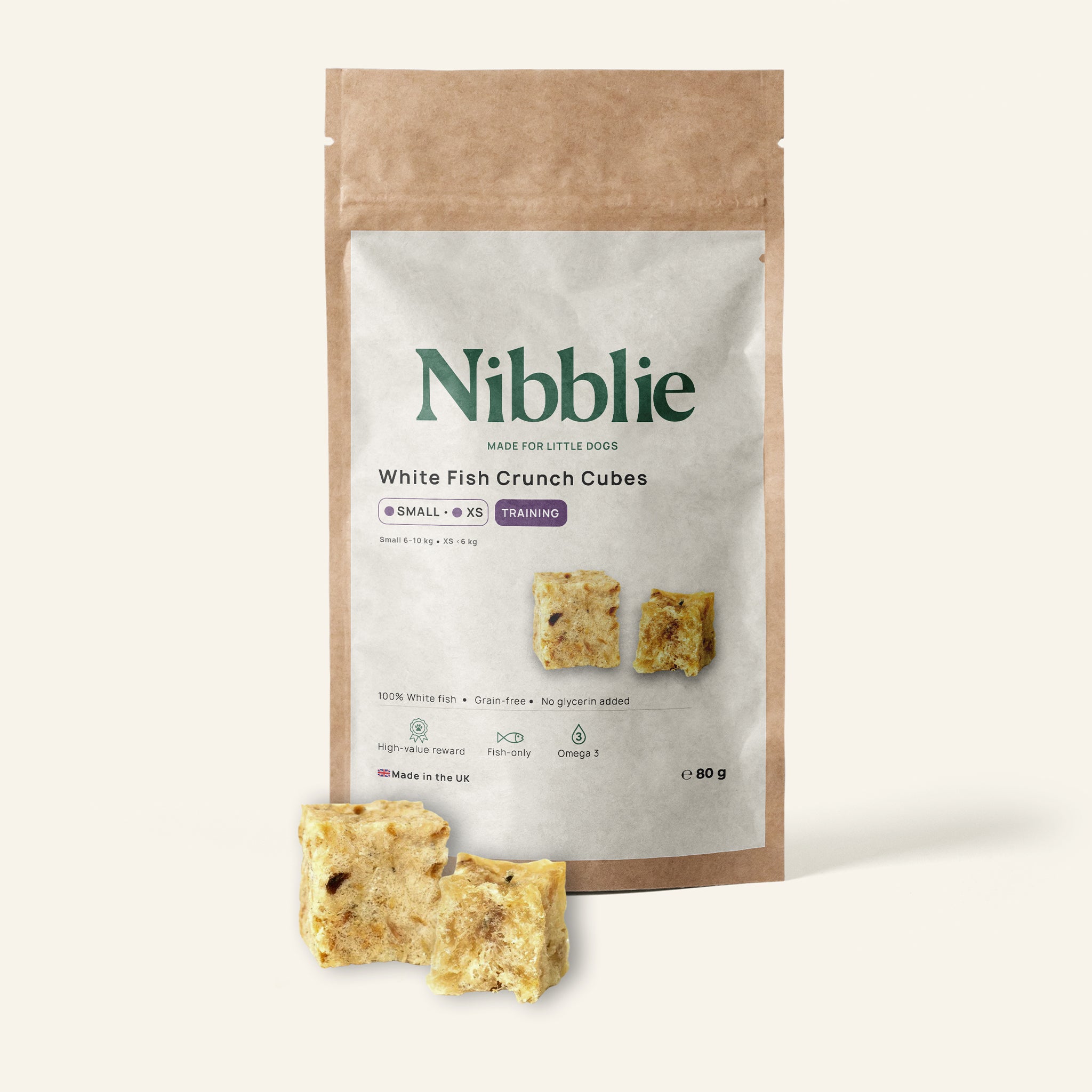 Nibblie White Fish Crunch Cubes 80g pack on warm linen with cubes in front; natural, air-dried white-fish treats.