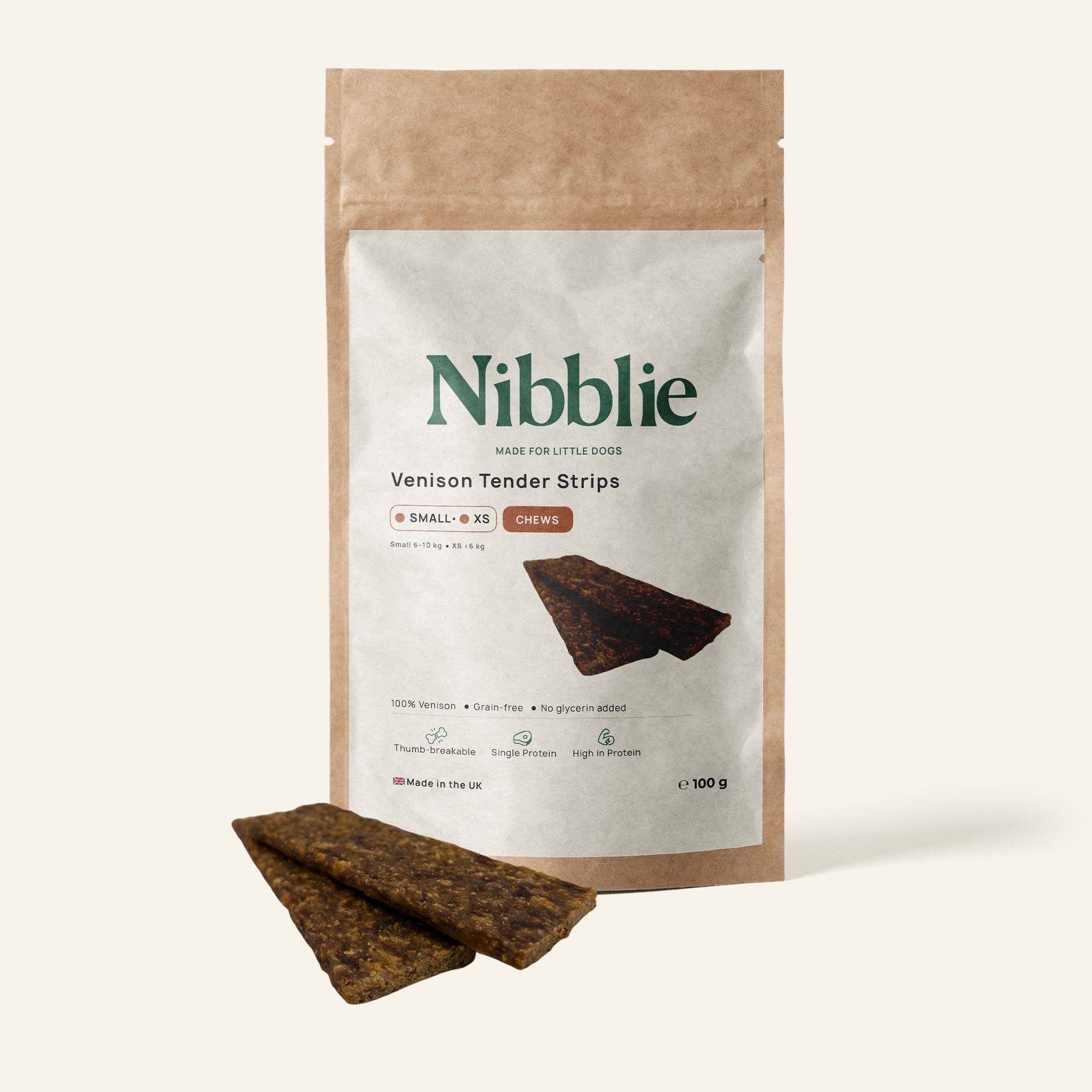 Nibblie Venison Tender Strips 100g pack on warm linen with strips in front; high-protein natural chew for small dogs.
