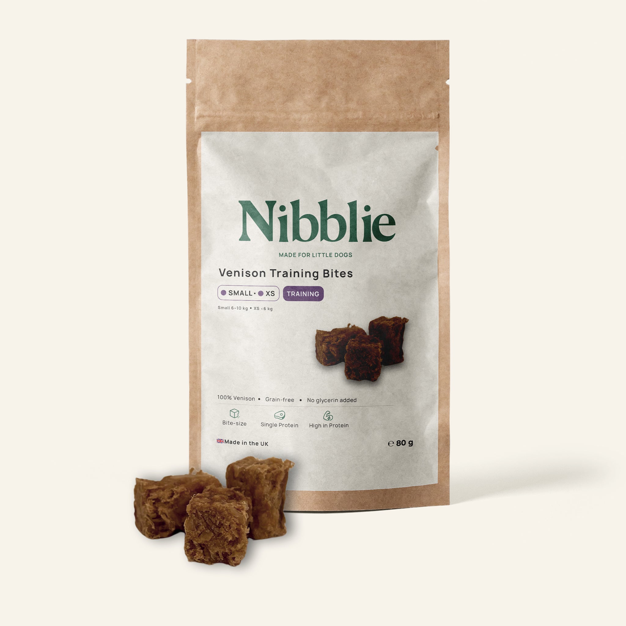 Nibblie Venison Training Bites 80g pack on warm linen with bites in front; high-value training treats for small dogs.
